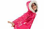 Young girl in a pink raincoat and woolly hood, making a dance pose