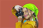 Young girl with green kerchief taking a photo with old 35mm film camera