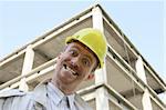 Crazy man with helmet in front of a building construction