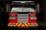 Red and yellow fire engine in garage bay in New England fires station.