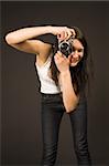 Young girl posing with camera isolated on black background