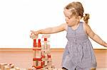 Cute little girl playing with wooden blocks