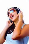 Blurrier portrait   of young  female listening music via earphones. Focused on face.