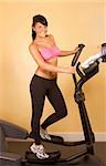 Young woman working out on elliptical machine