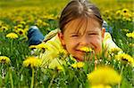The little girl lays on a lawn among yellow flowers