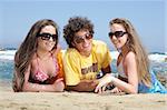 three happy teenagers having fun on the beach