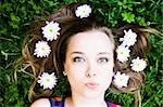 Summer Kiss. Woman with flower in hair laying on grass.