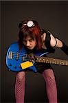 Sensual rock girl in crazy outfit with bass guitar