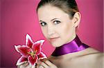 beauty portrait of a young woman with a ribbon and a lily flower