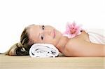 a young beautiful woman is relaxing in spa - wellness with a flower lily