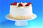 Strawberry meringue cake on a plate on blue background