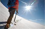 Lone male mountain climber climbing a snowy ridge; Mont Blanc, Europe.