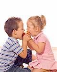 Little boy and girl bite an apple