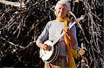 Banjo Player in Front of a Big Pile of Wood