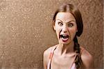 Screaming Young Woman in front of Gold wallpaper