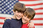 Brothers Hugging in Front of American Flag