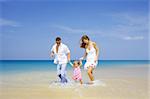 view of young family having fun on the beach