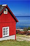 Red fishing hut with nets on the coast (Sweden)