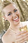 A beautiful young blond haired, blue eyed woman enjoying a glass of champagne