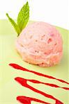 Delicious raspberries ice cream with syrup in green plate. Shallow depth of field
