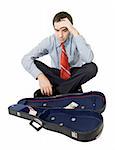 Desperate bankrupt businessman sitting by a violin case and a few coins - isolated