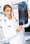 Surprised female doctor examining x-ray picture
