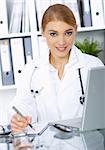 Smiling female doctor writing notes in clipboard
