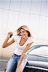 Young woman holding keys to new car