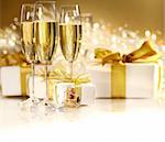 Glasses of champagne with gold ribbon gifts