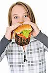 Teenage girl eating a big hamburger isolated on white background