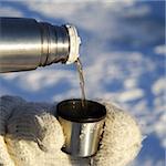 pouring tea outdoors in the winter with mittens