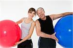 senior adult and daughter exercising with fitness ball in gym