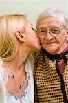 A young woman kissing an older one  (focus on the elderly) - part of a series.