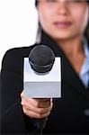 A woman is holding a microphone to the camera. Shot against white background.