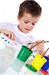 Boy concentrating at painting with watercolors - isolated