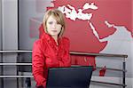 beautiful news television presenter in front of the laptop and looking at the camera