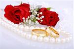 Still life with golden wedding rings and red roses