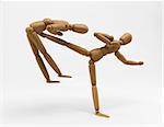 3D image of a wooden mannequin performing a karate kick over the opponent