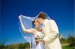 bride and groom kissing in the park