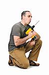 Kneeling handyman blowing on his cordless drill