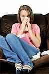 Teenage girl with a cold sitting in a chair with tissue box