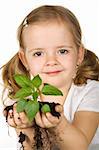 Little girl holding young plant with soil - isolated