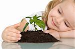 Little girl looking at a young plant wondering - closeup, isolated