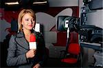 young beautiful television corespondent on the air in front of the video camera smiling
