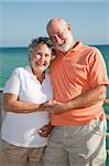 Portrait of a happy senior couple enjoying a seaside vacation.