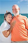 Senior couple on vacation - he's giving her rabbit ears.