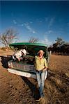 Man and woman in cowboy hats with old truck