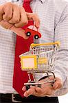 Shopping concept - Hand putting a car on a trolley shop