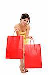 Mid adult woman holding red shopping bags on white background