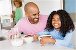 Father Sitting With Daughter As She They Eat Breakfast With Her